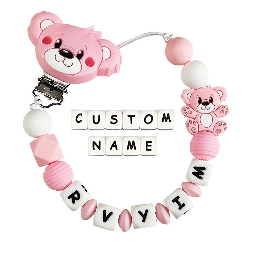 Pink teddy bear-shaped pacifier clip with customizable name on a white background