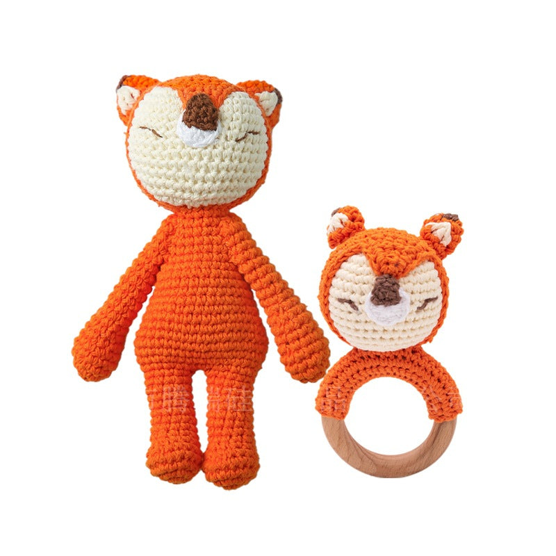 Crocheted fox toy and ring on a white background