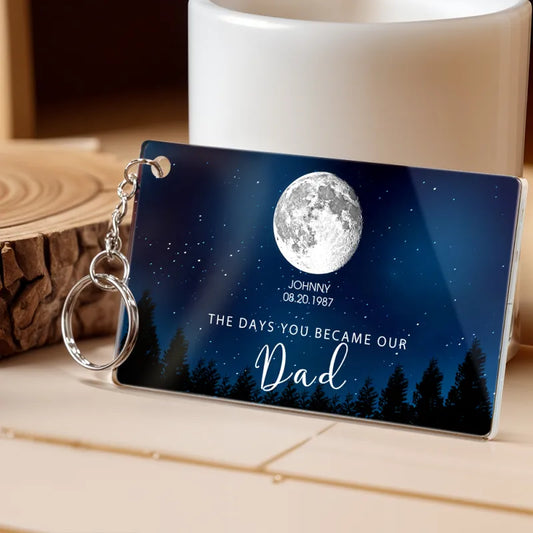 Personalized keychain with moon and tree design on a wooden surface