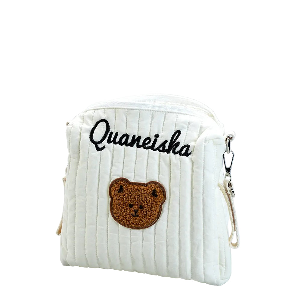 White textured pouch with a bear patch and embroidered name on a light background