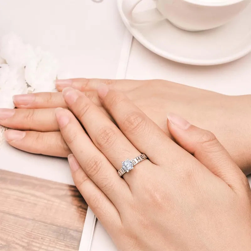 Hand wearing a ring with a blue gemstone on a light background
