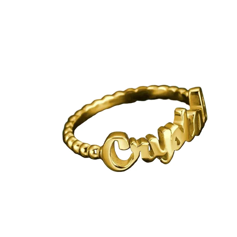 Gold ring with 'Cruzan' engraving on a dark stone surface