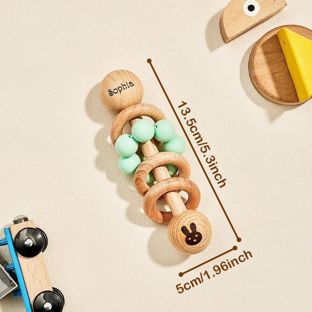 Wooden teething ring with beads and measurement details on a beige background