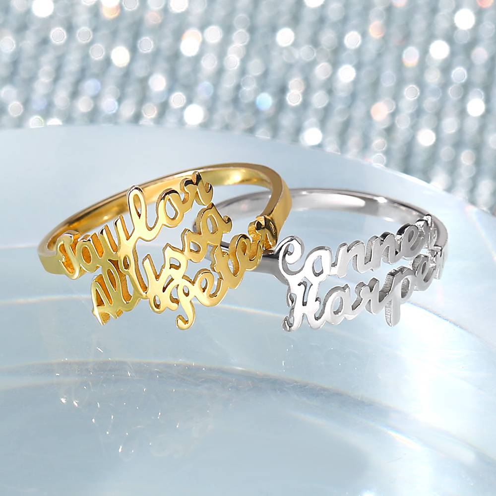 Gold and silver name bracelets on a reflective surface with a blurred glittery background