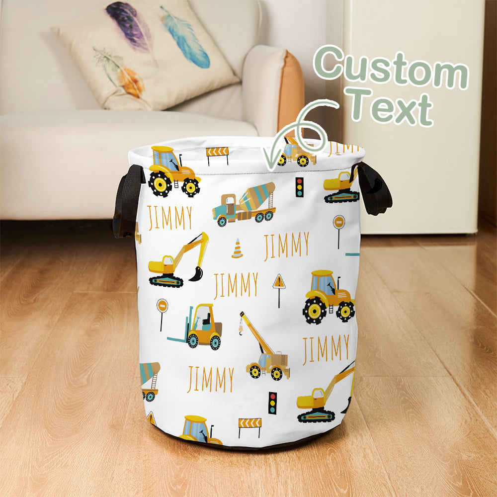 Laundry basket with construction vehicle pattern and 'Jimmy' text on a wooden floor.