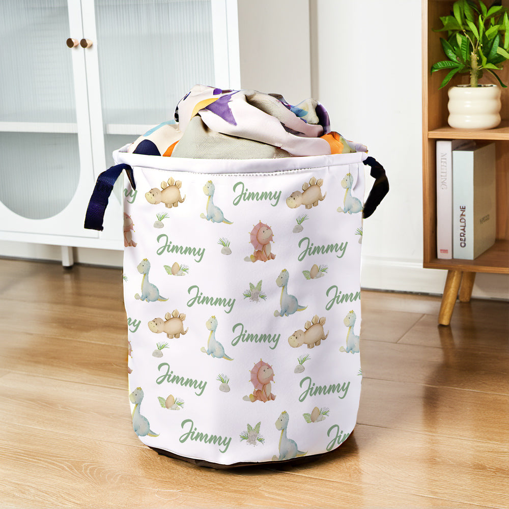 Laundry basket with dinosaur pattern and 'Jimmy' text on a wooden floor.