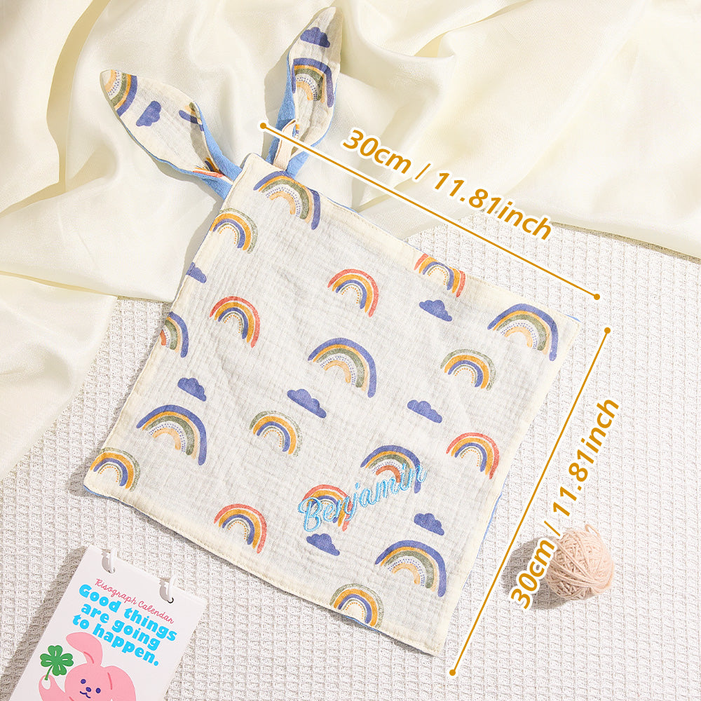 Baby blanket with rainbow pattern and measurements on a white background