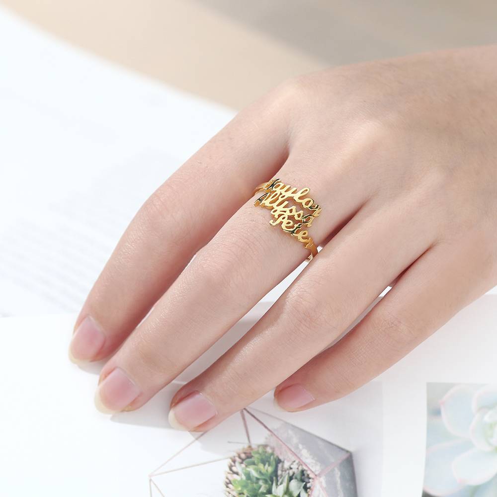 Gold ring with engraved text on a hand against a white background