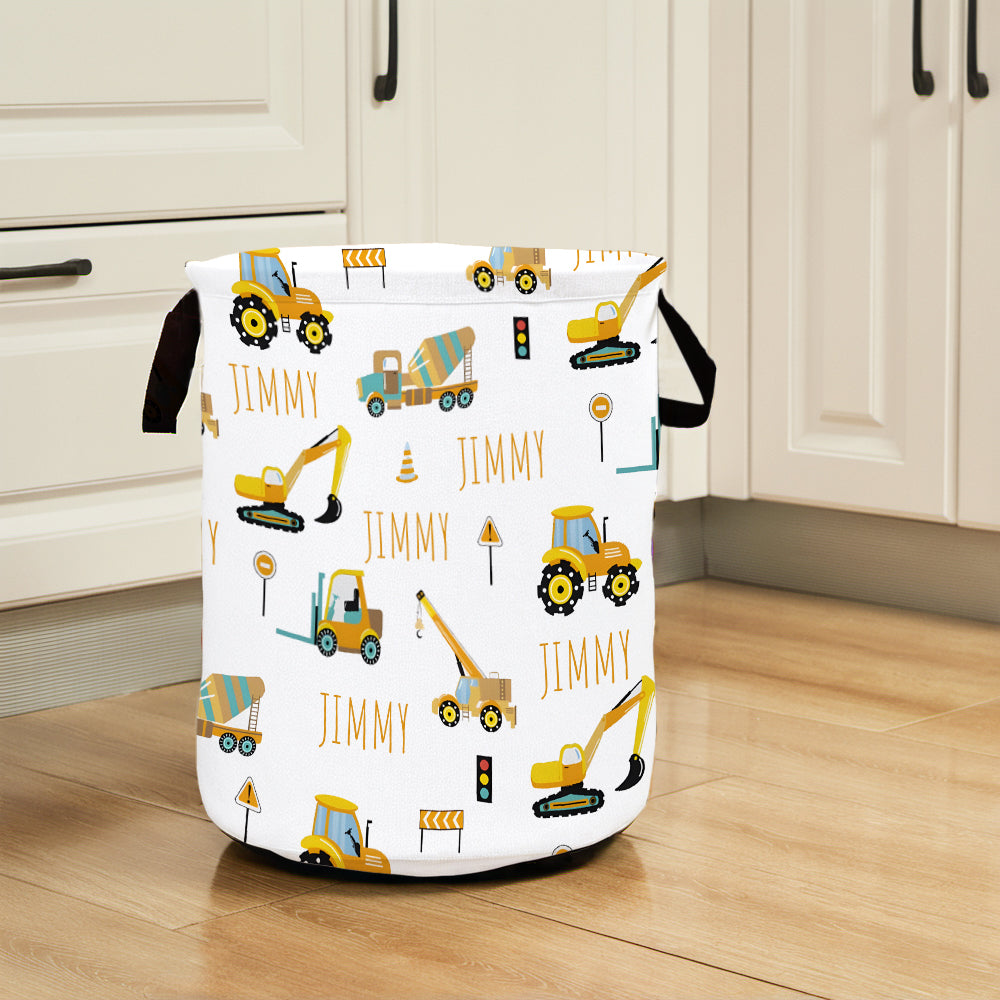 Laundry basket with construction vehicle pattern and 'Jimmy' branding on a wooden floor.