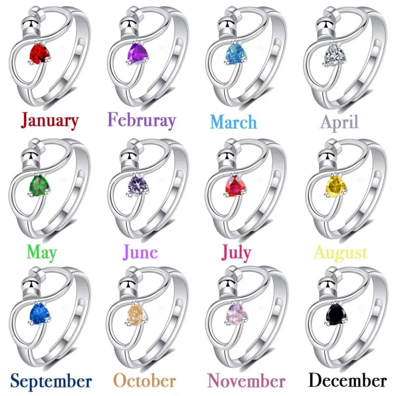 Silver rings with colored gemstones for each month, on a white background.