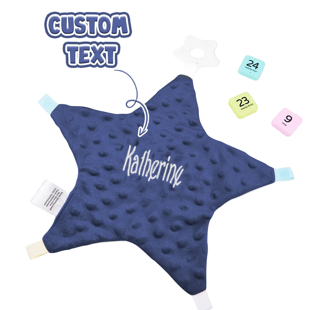 Blue star-shaped pillow with 'Katherine' text on a white surface with calendar and plant.