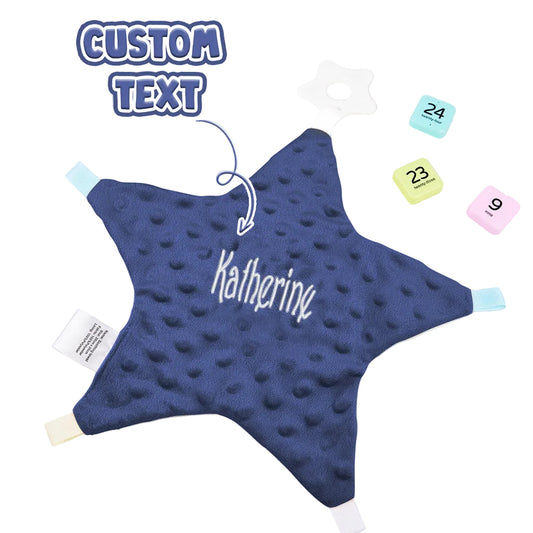 Blue star-shaped pillow with 'Katherine' text on a white surface with calendar and plant.