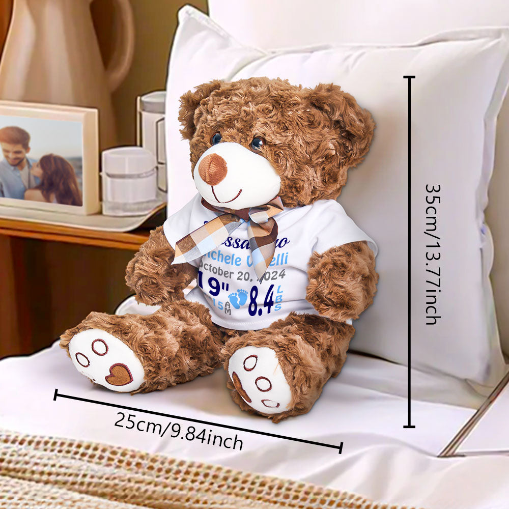 Brown teddy bear wearing a white shirt with text, sitting on a pillow with measurements indicated.