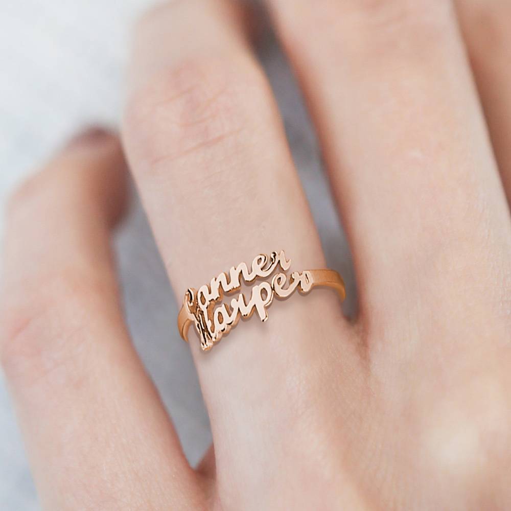 Rose gold ring with 'Kanner Harper' engraving on a hand against a neutral background