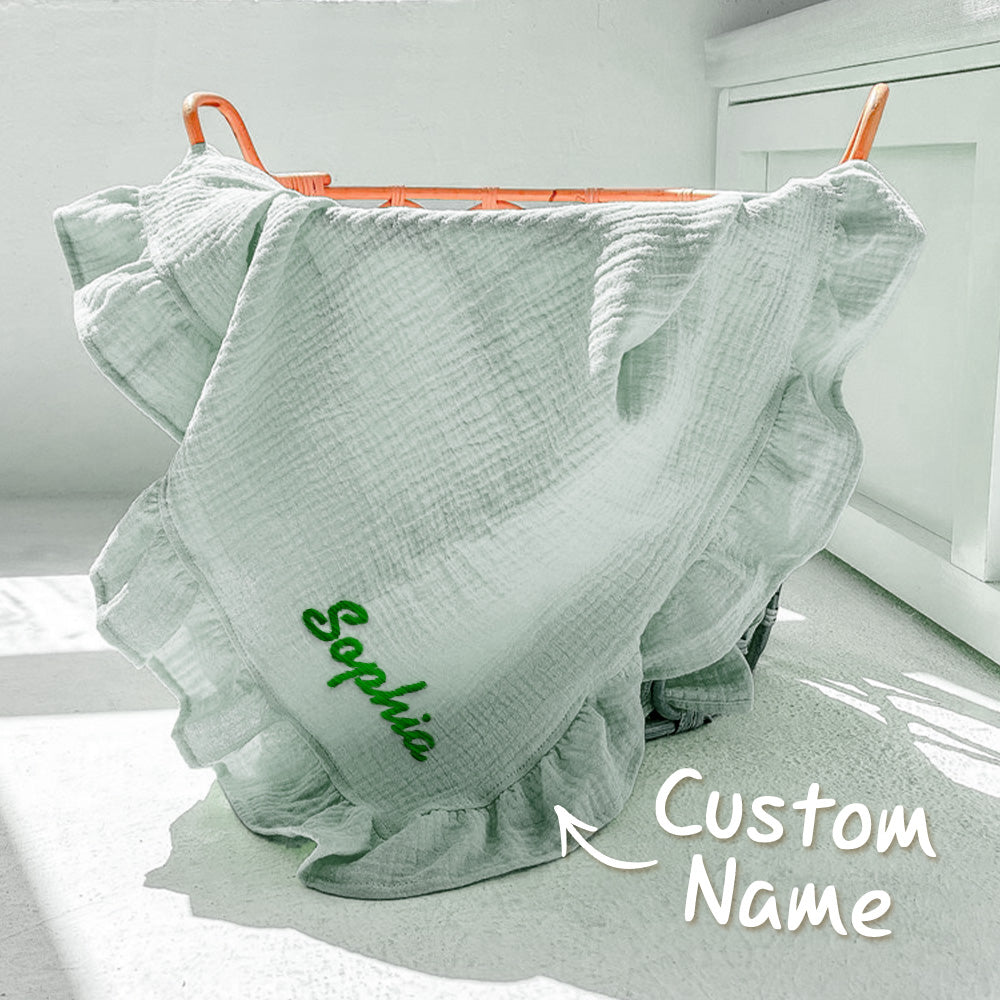 Light green ruffled fabric with 'Sophia' embroidered on it, hanging on a rack.