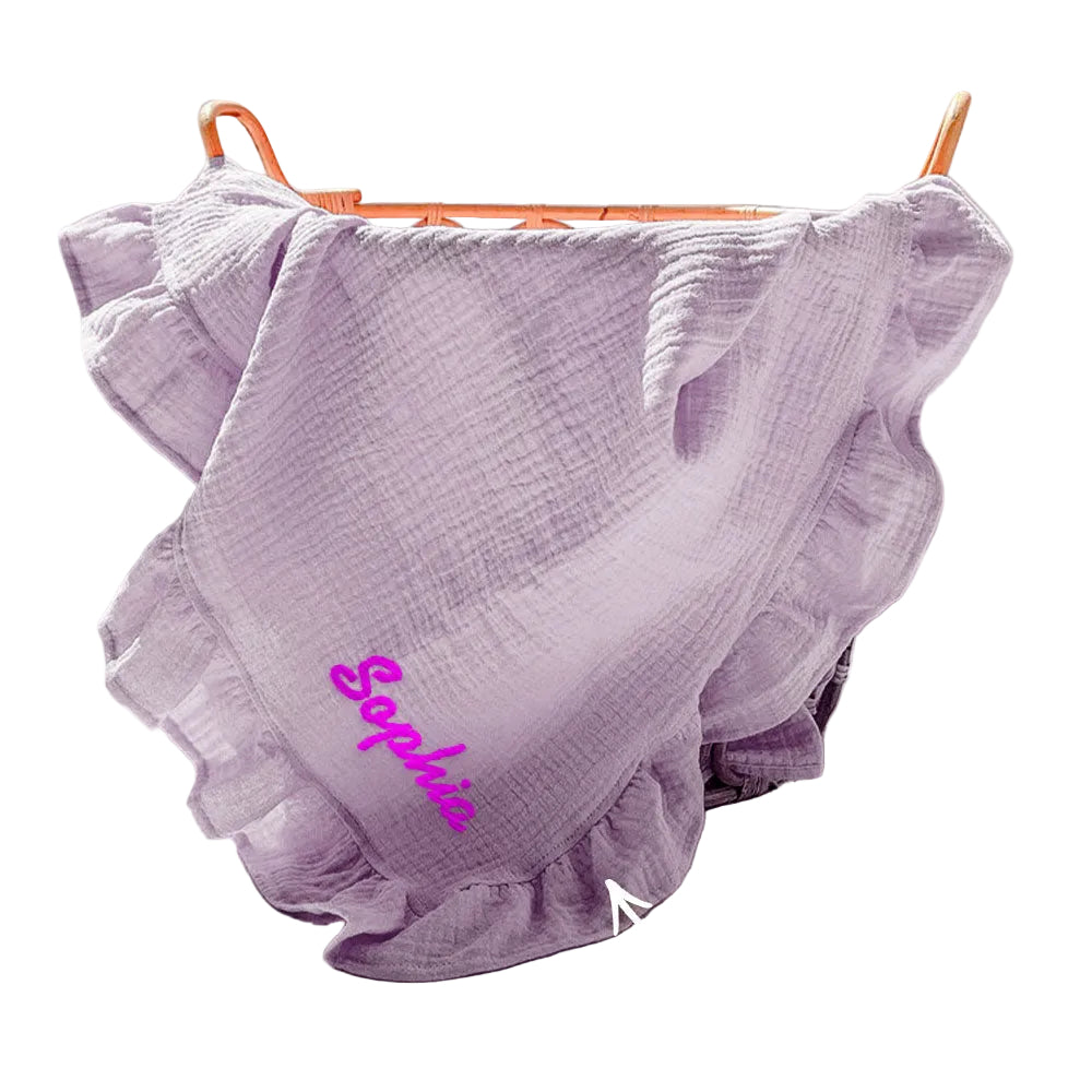 Purple ruffled blanket with 'Sophie' embroidered on it, hanging on a rack.