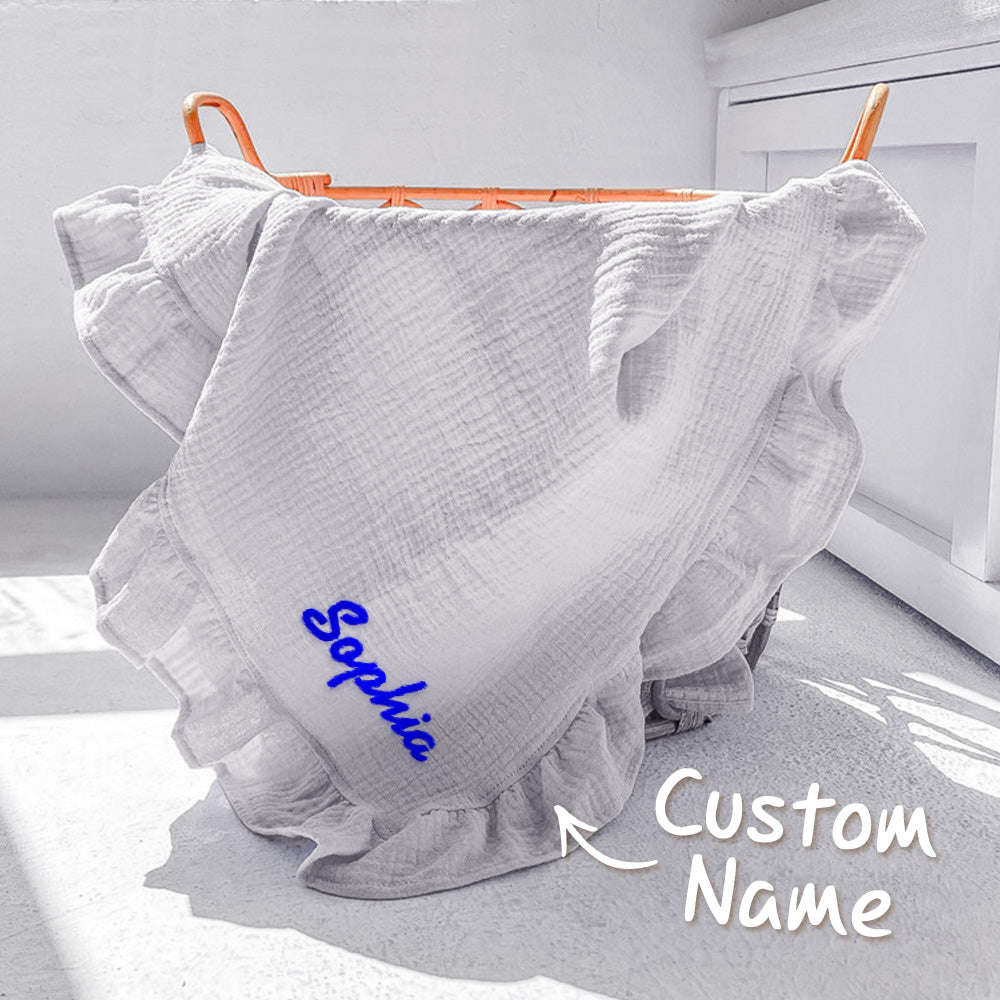 White textured fabric with 'Sophia' embroidered on it, hanging on an orange rack.