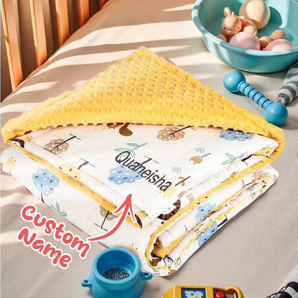 Baby blanket with cartoon design on a bed, featuring the brand 'Quaheisha'.