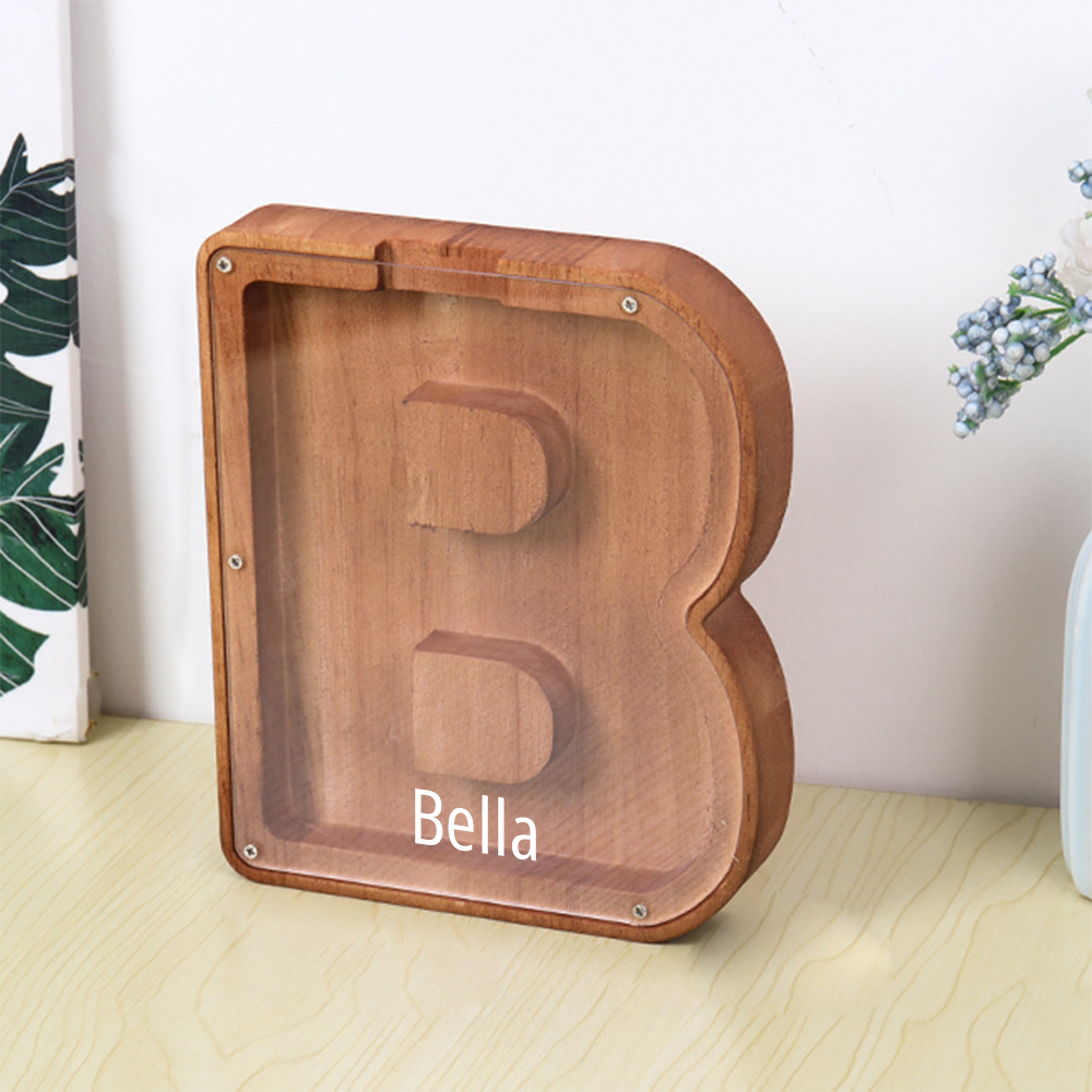 Wooden letter 'B' with 'Bella' engraved on a light wooden surface.