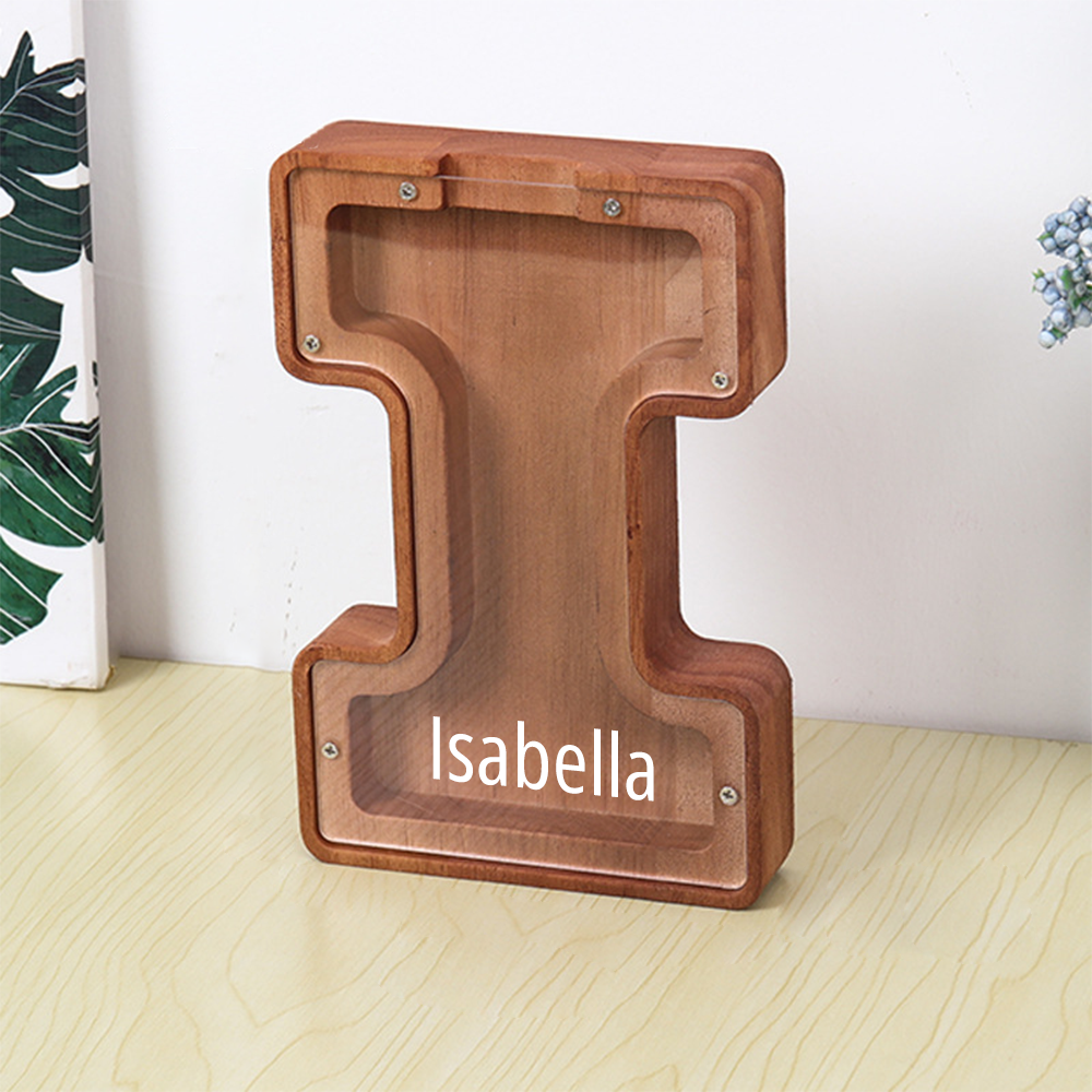 Wooden letter 'I' with 'Isabella' engraved on a light wooden surface.