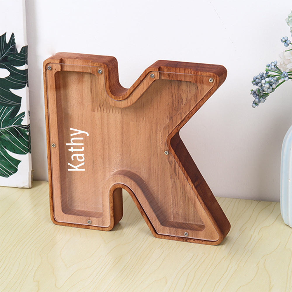 Wooden letter 'K' with 'Kathy' engraved on a light wooden surface.