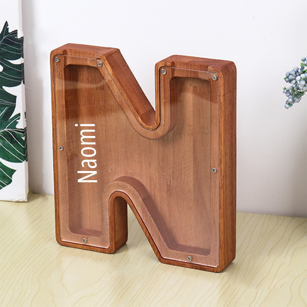 Wooden letter 'N' with 'Naomi!' branding on a light wooden floor.