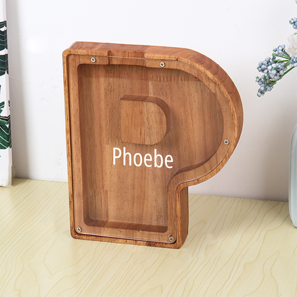 Wooden letter 'P' with 'Phoebe' engraved on a light wooden surface.