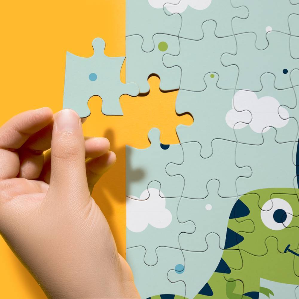 Child's hand placing a puzzle piece on a dinosaur-themed puzzle with a yellow background