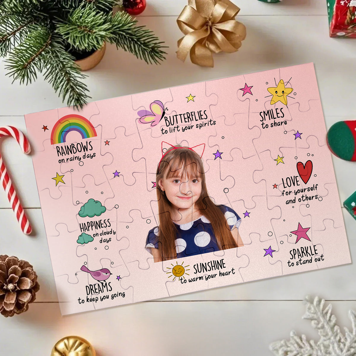 A completed personalized jigsaw puzzle featuring a child's portrait in the center with whimsical illustrations and positive phrases around the edges, styled on a light tabletop with holiday decorations.