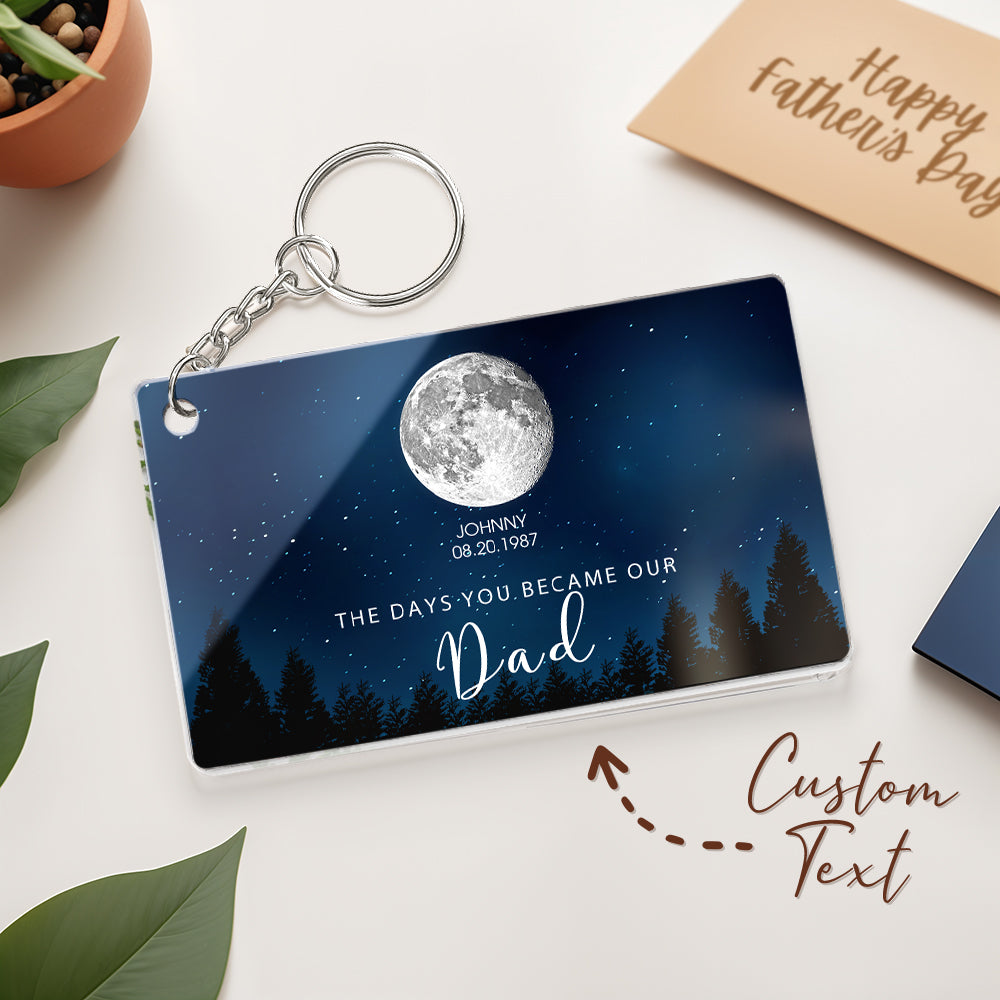 Personalized keychain with moon and tree design on a white surface with 'Happy Father's Day' card.