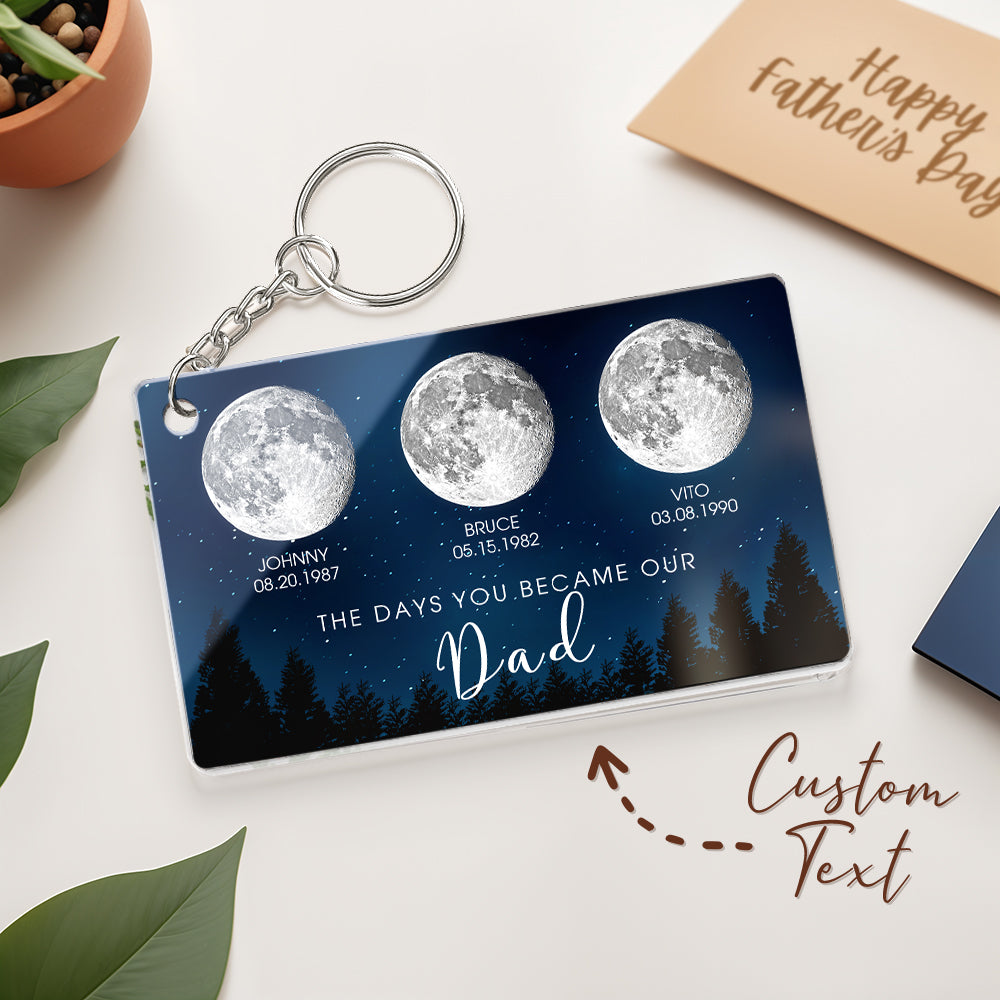 Keychain with moon phases and personalized text on a white surface with a 'Happy Father's Day' card.