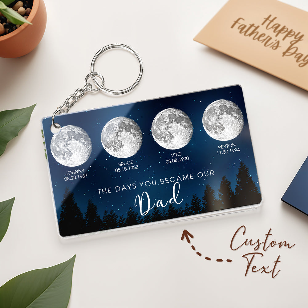 Keychain with moon phases and personalized text on a white surface with a 'Happy Father's Day' card.