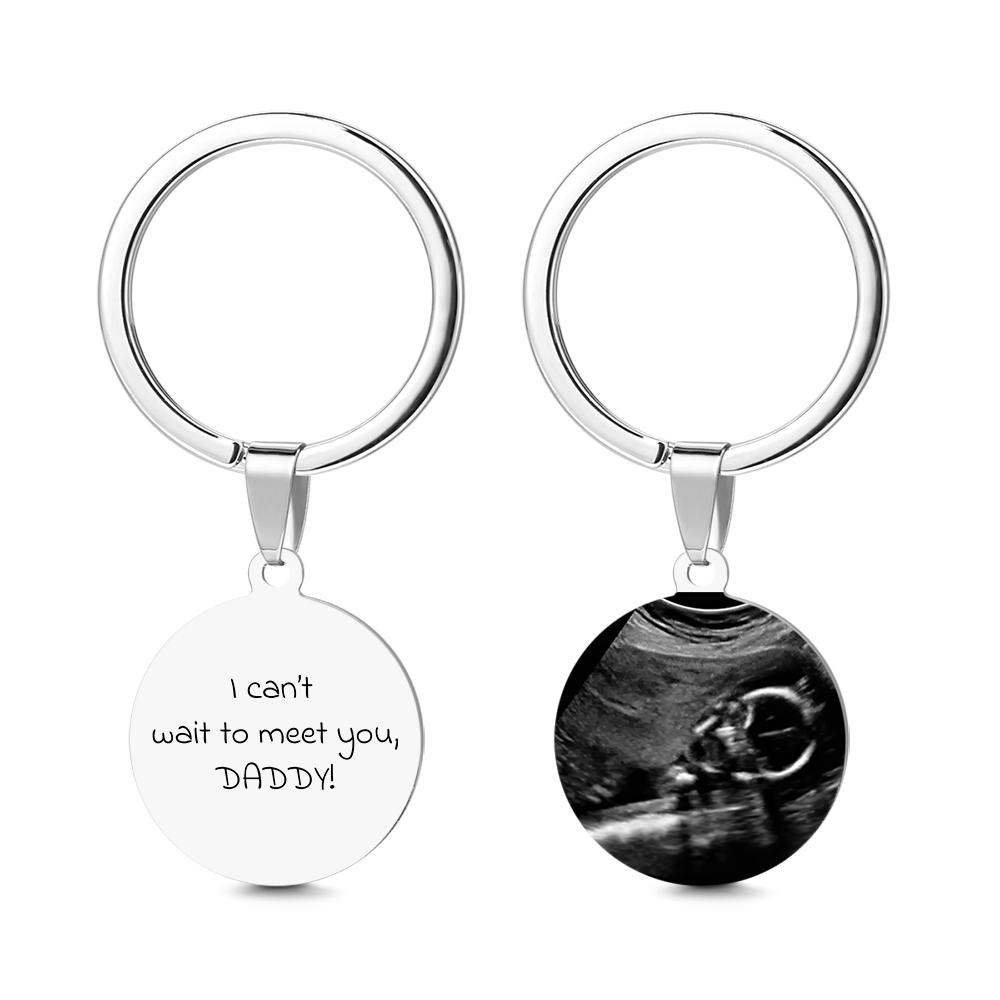 Two keychains with one displaying 'I can't wait to meet you, DADDY!' text and the other showing an ultrasound image.