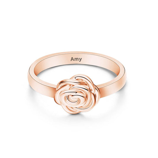 Rose gold ring with rose design and 'Amy' engraving on a white background