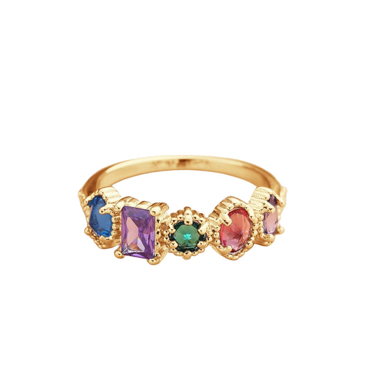 Gold ring with colorful gemstones on a soft background