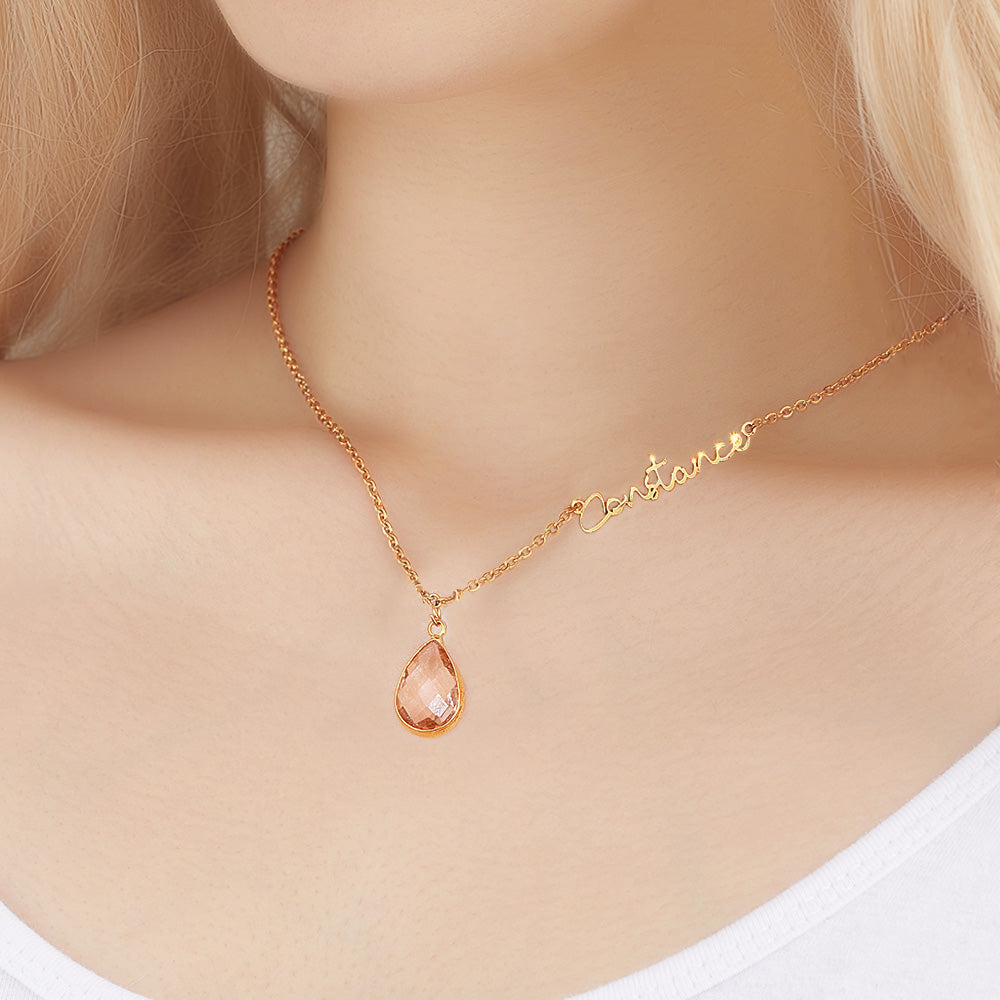 Gold necklace with a teardrop-shaped pendant on a model