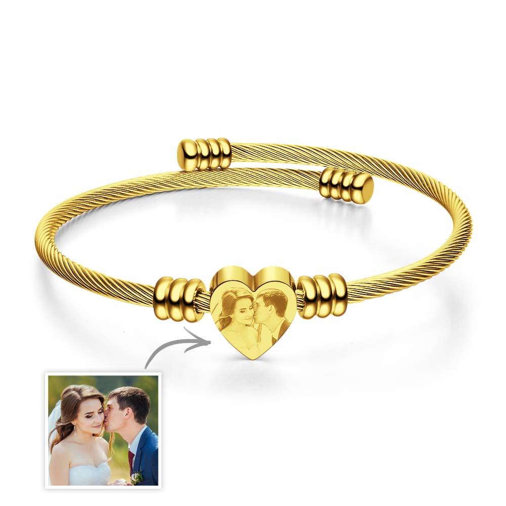 Gold bracelet with heart-shaped charm featuring a couple's photo on a white background