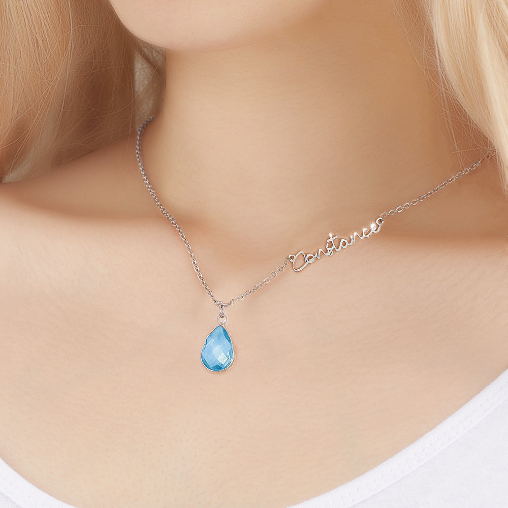 Necklace with a blue teardrop pendant on a model