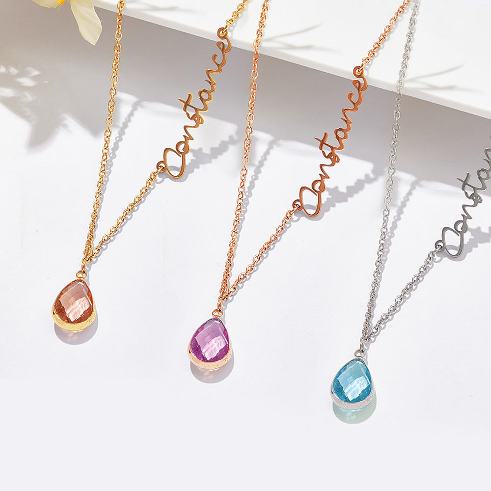 Three necklaces with teardrop-shaped gemstones on a white surface