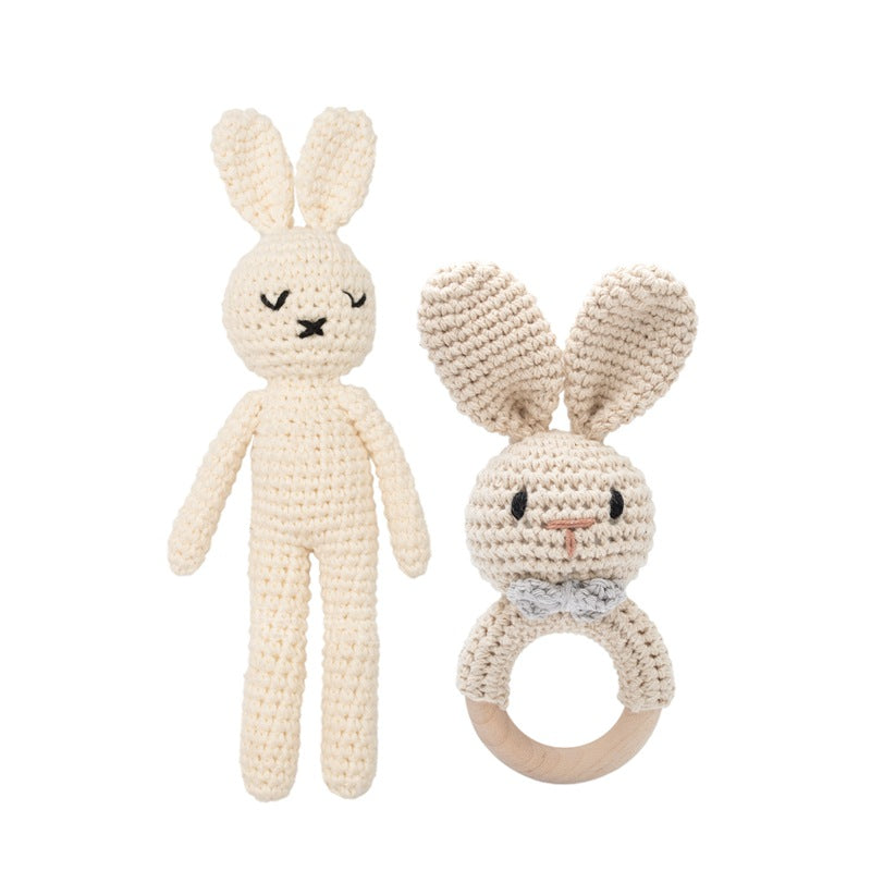 Crocheted bunny plush toy and rattle on a white background
