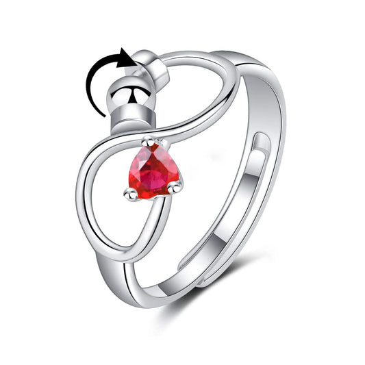Silver ring with a red gemstone on a white background