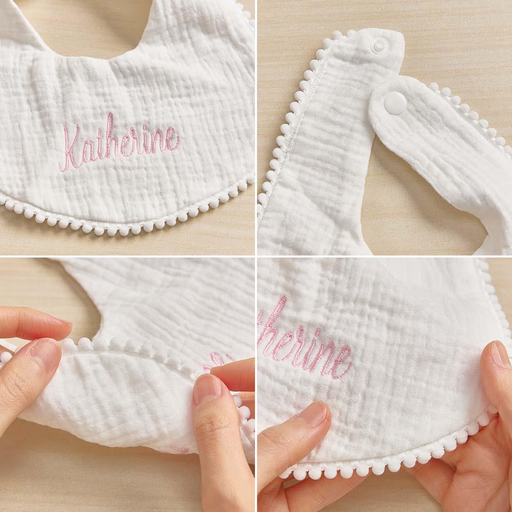White baby bib with embroidered name 'Katherine' on a beige background