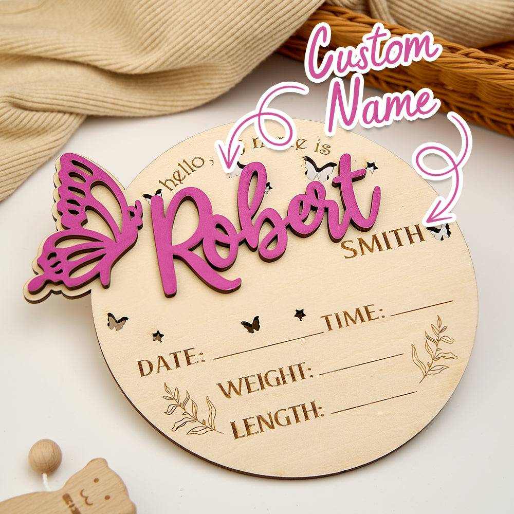Wooden baby milestone plaque with 'Custom Name' text, butterfly design, and placeholder details on a neutral background.