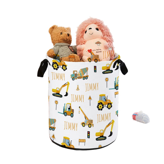 Toy storage basket with construction vehicle pattern on a bed with stuffed animals.