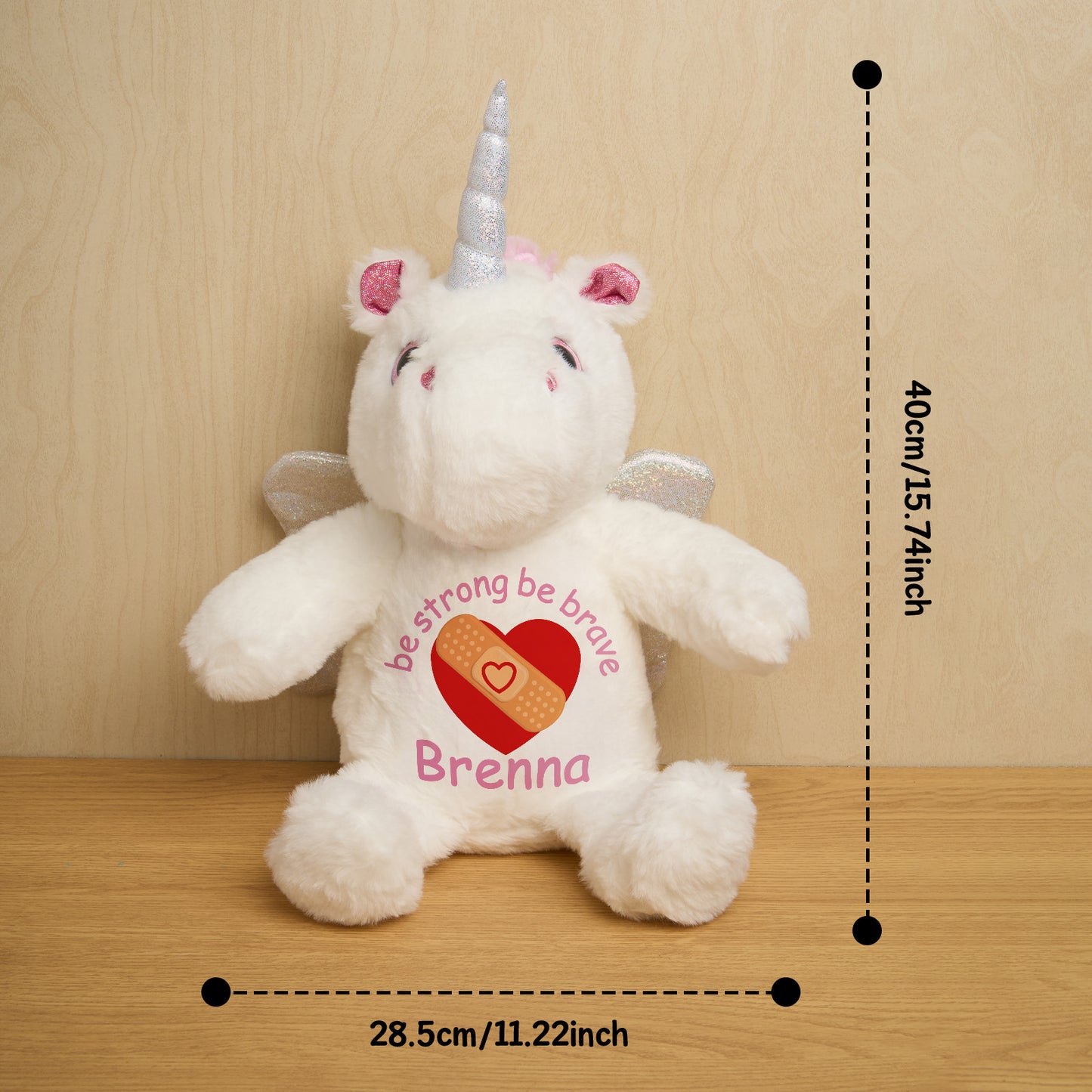 White unicorn plush toy with measurements on a wooden surface