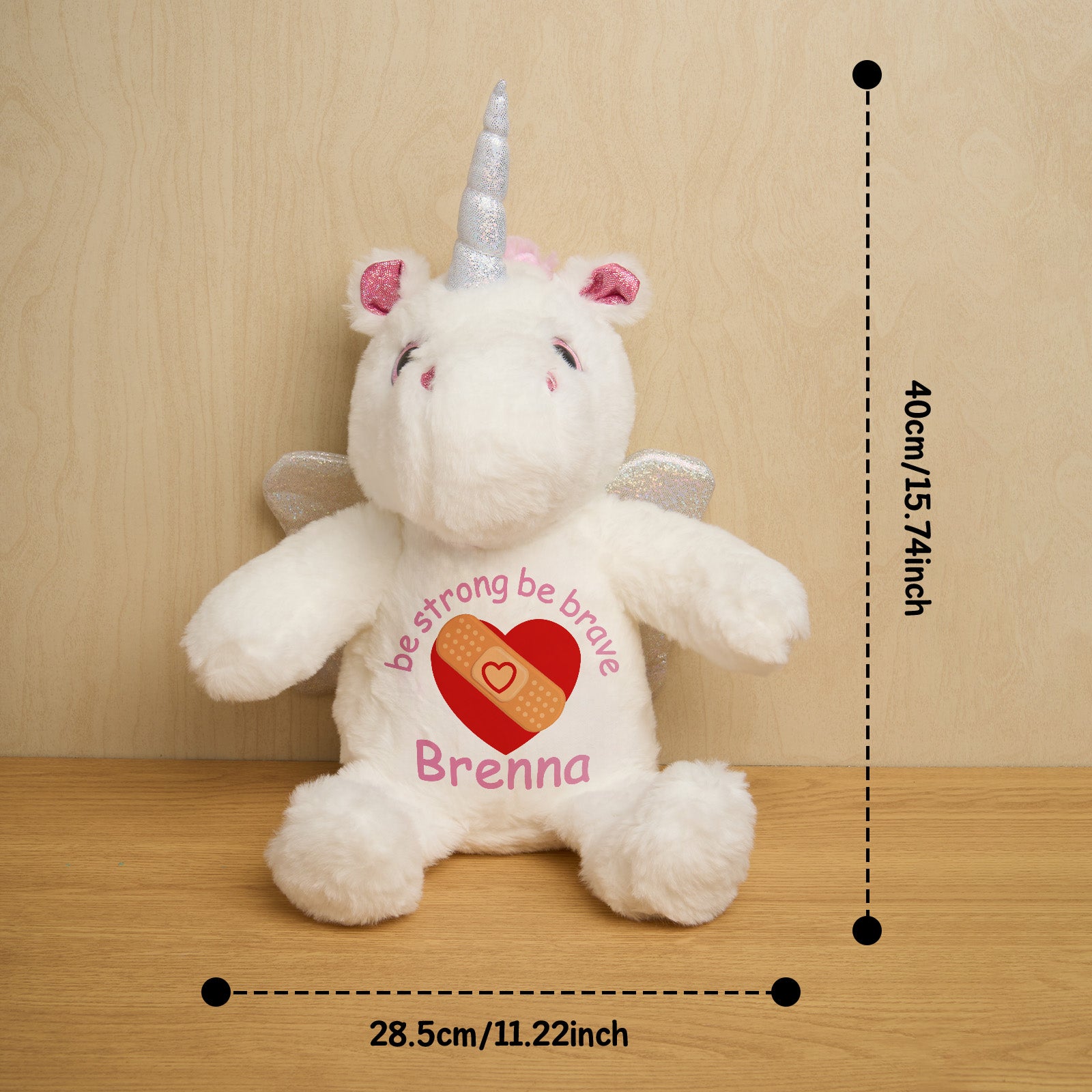White unicorn plush toy with measurements on a wooden surface