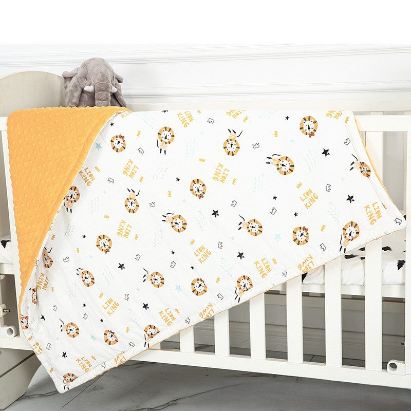 Baby crib with a white blanket featuring lion prints and an orange border.