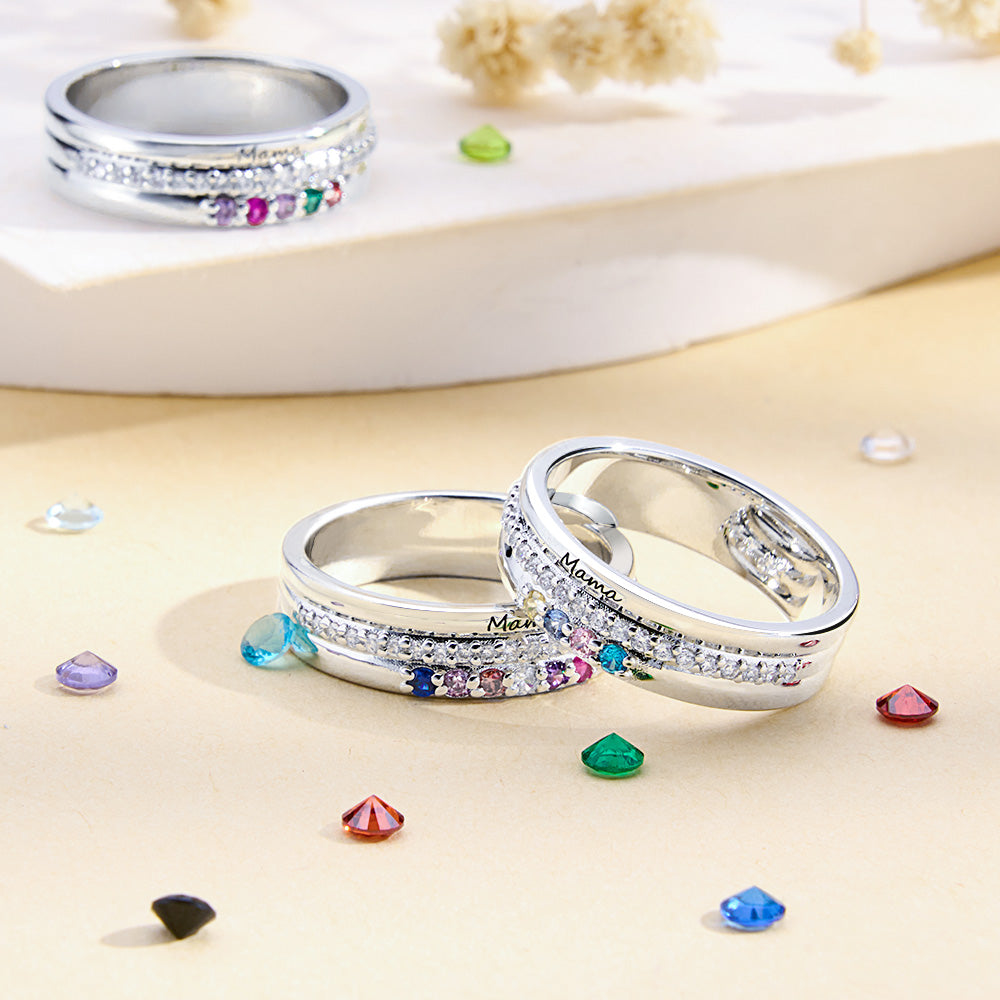 Silver rings with colorful gemstones on a beige surface