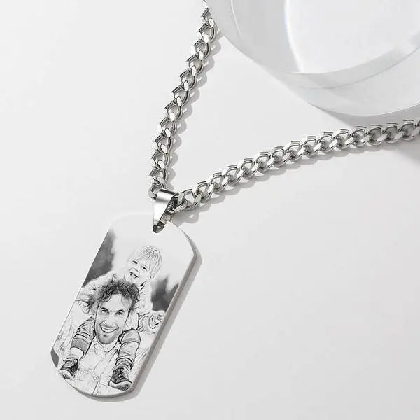 Silver chain necklace with a dog tag engraved with a photo of a man and child on a white background.