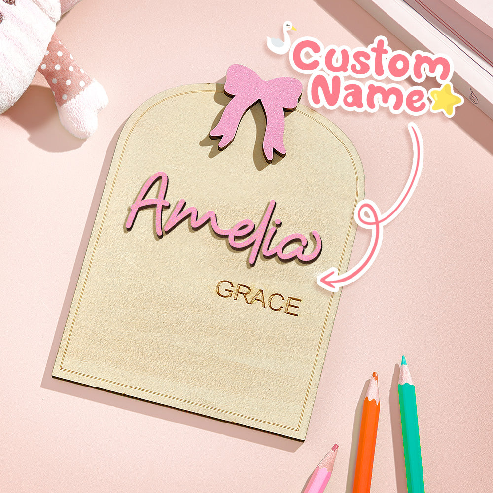 Personalized nameplate with 'Amelia' and 'Grace' on a pink background with stationery items.